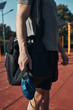 © Przemek Klos - Young man standing in street workout calisthenics park holding the face mask need to avoid virus infection and to prevent the spread of disease in time of coronavirus