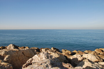 blue sea stones and clear sky. mediterranean sea, sunny day. in the foreground are textured stones i