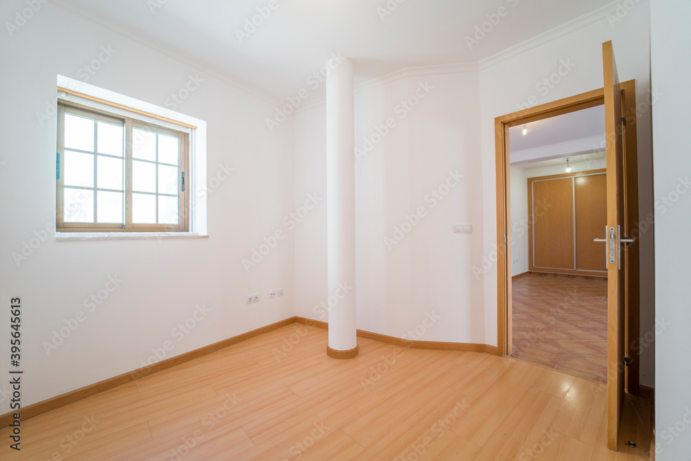Empty room with wooden floating laminate flooring, door and window. House interior, wide bedroom space. Newly recently painted new apartment or house. Wood floor. Real state and property management - obrazy, fototapety, plakaty 