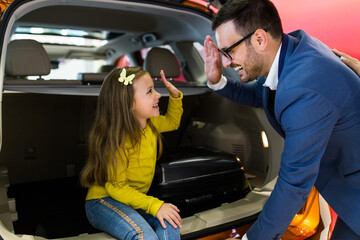 Wall Mural - Father and daughter buying a new car at the car showroom.