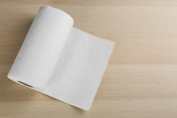 Roll of paper tissues on wooden table, top view. Space for text