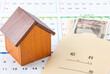 住宅ローン返済計画・家賃支払いのイメージ（家の模型と給料袋とカレンダー）