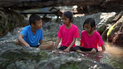 Wall Mural - Kids playing in waterfall on mountain of travel summer holiday