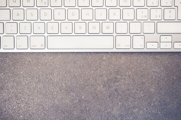 Canvas Print - Top view of a computer keyboard on a stone textured surface with copy space