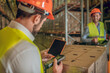 © zinkevych - Two warehouse workers in helmets checking goods
