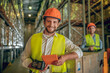 © zinkevych - Two warehouse workers in helmets checking goods and looking positive