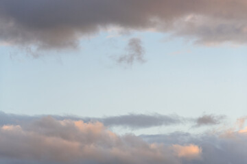 Colorful blue sky and clouds highlighted by setting sun, as a nature background
