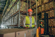 © zinkevych - Two workers in helmets and vests preparing containers for delivering