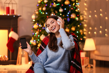 Sticker - Beautiful young woman listening to Christmas music at home