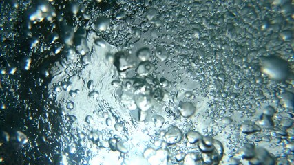 Wall Mural - Underwater air Bubbles through water surface, natural slow motion under water scene. Air bubbles floating from the sea bottom up to  water surface