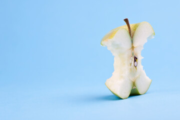 Wall Mural - Green apple core. Studio photo isolated on blue background. Selective focus on object.