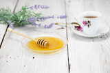Fototapeta Lawenda - Miód i filiżanka herbaty na białym stole
