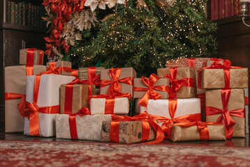 Beautiful Christmas gift boxes on floor near fir tree in room