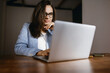 © Daria - A woman at work does business on a laptop. Woman businessman working on laptop in office. Student in glasses to study on a laptop, vide connection.