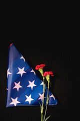 Wall Mural - top view of red carnation american flag on black , funeral concept
