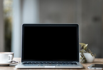 Wall Mural - Mockup of laptop computer with empty screen with coffee cup and smartphone on table of the coffee shop background,Black screen