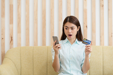 Young Asian woman holding credit card and using mobile phone, Online shopping concept