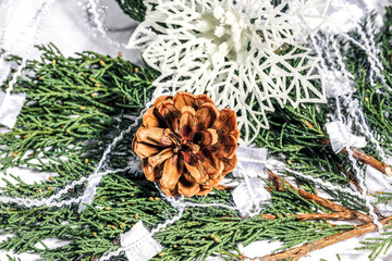 Christmas composition. Gift, fir tree branches and cones, white decoration on yellow gift box. Christmas, winter, new year concept.,