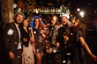 © maxbelchenko - Happy friends throwing confetti and jumping while enjoying party. Group of  young people celebrating together winter holiday. Confetti is fun. Party, celebration, drink, birthday concept.