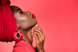 profile of african american woman in stylish outfit and turban with closed eyes isolated on red