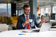 © Red Riding Hood - Young businessman having an online meeting on a laptop in an office and drinking coffee.