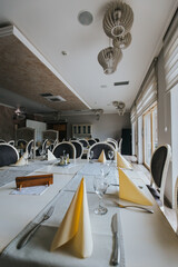 Wall Mural - Vertical shot of restaurant tables and chairs with glassware and napkins