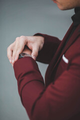 Poster - Vertical shot of a man in a modern suit fixing his watch