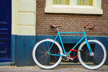 Sporty Old Style Blue Bicycle On Brown And White Wall Background. Blue And Brown Bicycle Parked  Exterior. Red Brick Wall Background