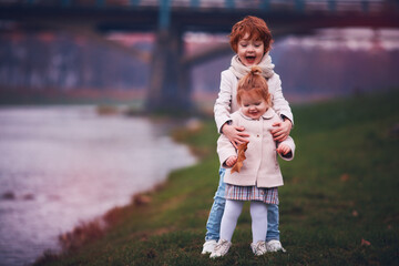 cute happy redhead kids, siblings are plaing outdoors. autumn season