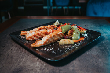 Sticker - Grilled fish with cut bell pepper on a black plate