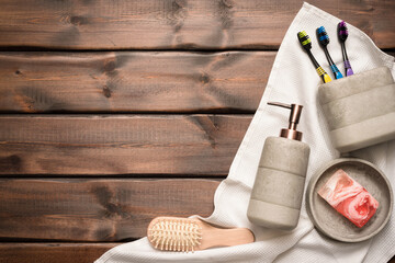 Wall Mural - Bath accessories, soap dispenser, comb, towel and toothbrush on the wooden table background with copy space. Hygiene.