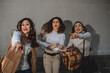 © Pintau Studio - Three caucasian women surprised, trying to catch something in front of them. Sale, shopping, occasion, scared, rush, hurry concept.