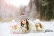 © alexkich - Happy family playing and laughing in winter outdoors in the snow. City park winter day.