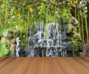 wooden planks with blurred waterfall garden background. space for product placement