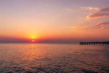 amazing picturesque view at a pier in sea with calm water and beautiful sunset on a background. scen