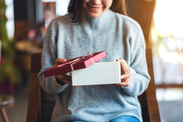 Wall Mural - Closeup image of a beautiful young woman opening a gift box