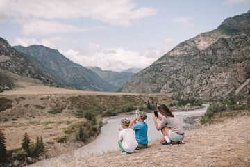 Poster - people sit on the edge of the bank in the river valley