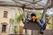 © Yulia Raneva - father with cute 6 year old son swinging on large bench swings. brothers with dad walking on playground