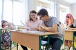 © Valerii Honcharuk - Lesson in class of high school students, female teacher sitting at desk with student