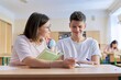 © Valerii Honcharuk - Lesson in class of high school students, female teacher sitting at desk with student