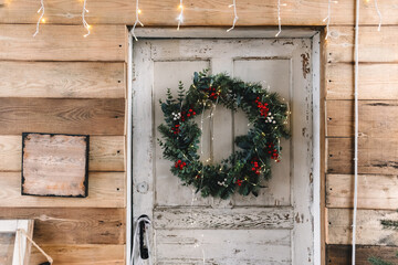 Wall Mural - Wooden white door to the house decorated with Christmas wreath.