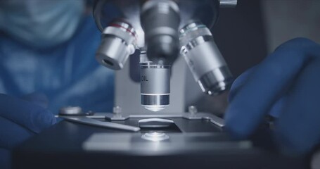 Wall Mural - close-up shot of sample slide and microscope with metal lens at laboratory.