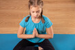 © AlexVP76 - Little girl do exercise on roll mat practicing yoga at home