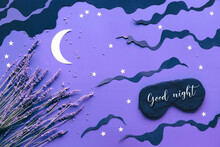 Sleep Mask With Lavender On Purple Color Background With Black Clouds, Moon And Stars. Text Good Night On The Mask. Quality Of Sleep, Aromatherapy, Scented Herbal Remedies. Creative Flat Lay.