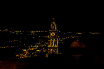 Wall Mural - Rooftops and church towers illuminated at night in Thira, Santorini in summertime