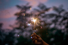 Person Holding Lighted Sparkler During Nighttime
