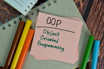 oop - object oriented programming write on sticky notes isolated on wooden table.