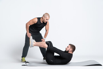 Wall Mural - sport man exercising with personal fitness trainer on white background