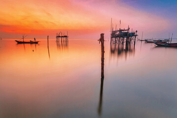beautiful view on sunrise with wooden boat as a subject at kenjeran beach,surabaya.indonesia