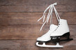 Pair of skates hanging wooden background. Space for text